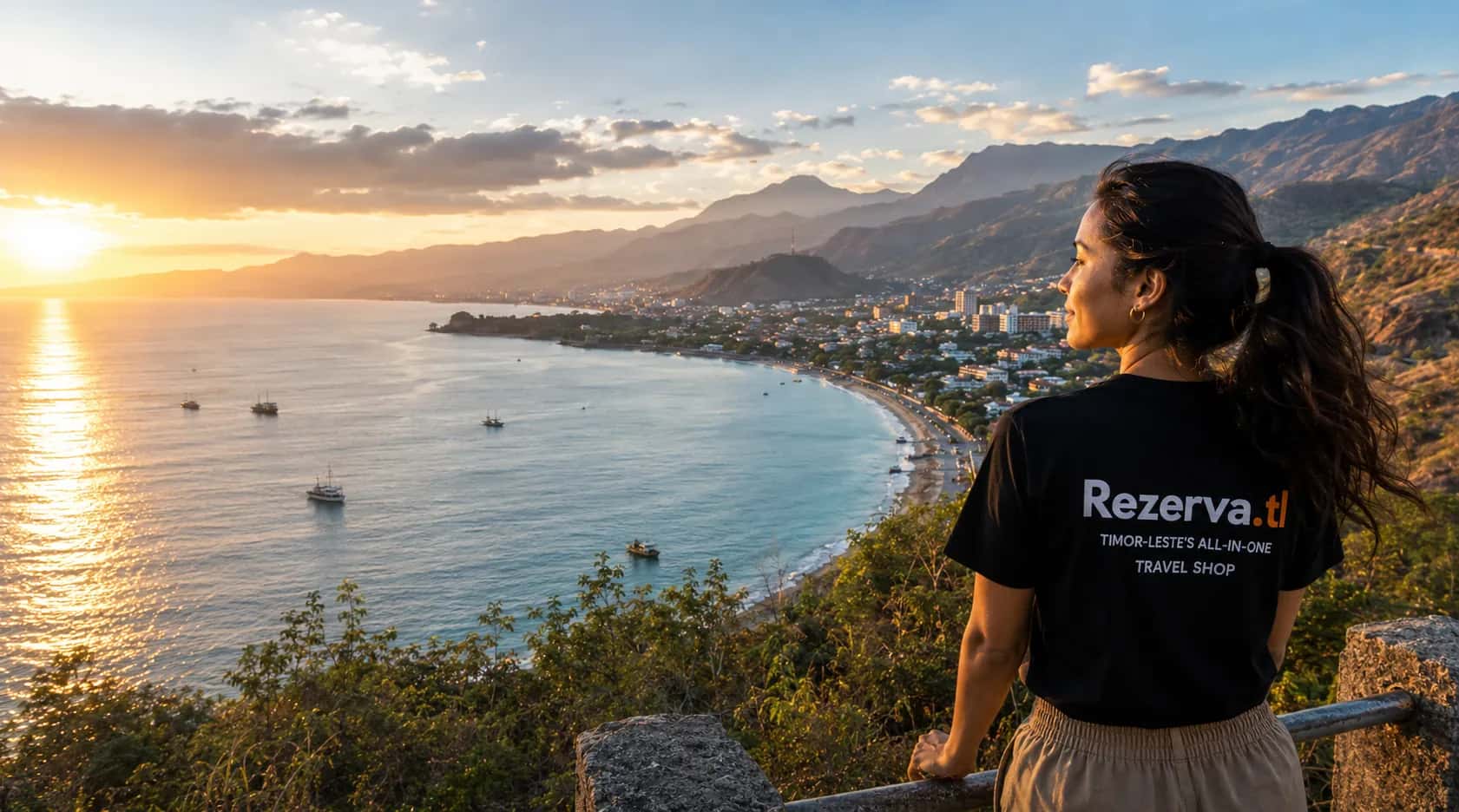 Woman in a Rezerva.tl shirt looking out over Dili bay at sunset, Timor-Leste